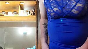 Crossdressing hottie in een blauwe jurk plaagt met haar tieten en pik